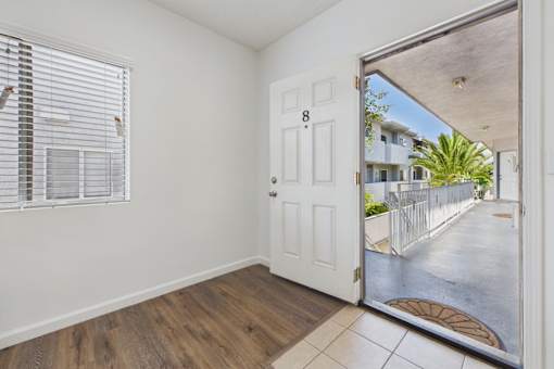 A white door with a number 8 on it is open to a patio.