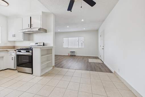 A kitchen with white cabinets and a stainless steel range hood.