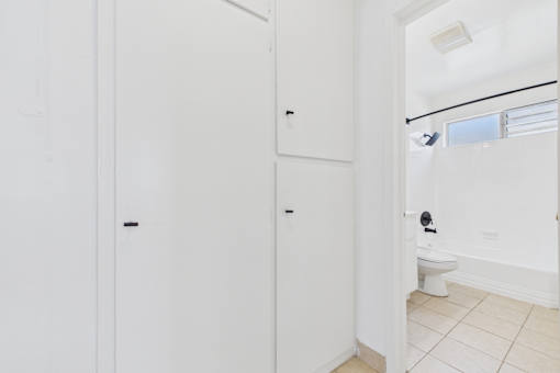 A white bathroom with a toilet and a white door.