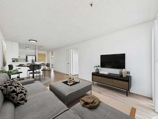 A living room with a grey couch and a wooden cabinet.