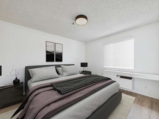 A bedroom with a large bed and a window with blinds.