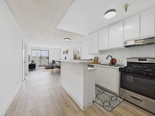 A kitchen with a white counter and a black stove.