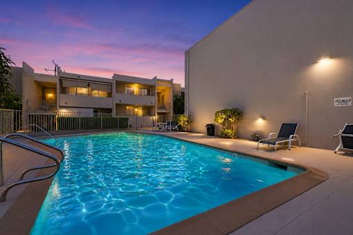 A swimming pool in a residential area with a building in the background.