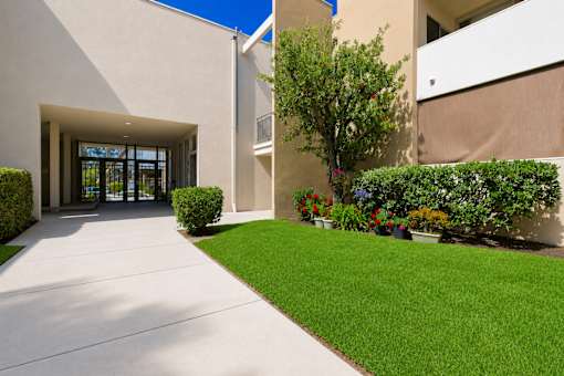 A building with a white exterior and a green lawn in front.