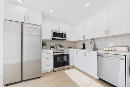A modern kitchen with stainless steel appliances and white cabinets.