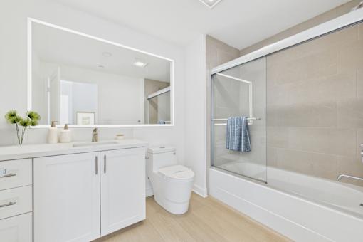 A white bathroom with a toilet, sink, and bathtub.