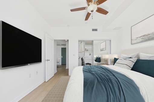 A bedroom with a large bed and a ceiling fan.