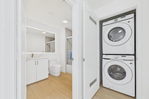 A white laundry room with a washer and dryer stacked on top of each other.