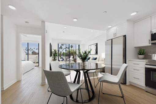 A modern kitchen with a dining table and chairs.