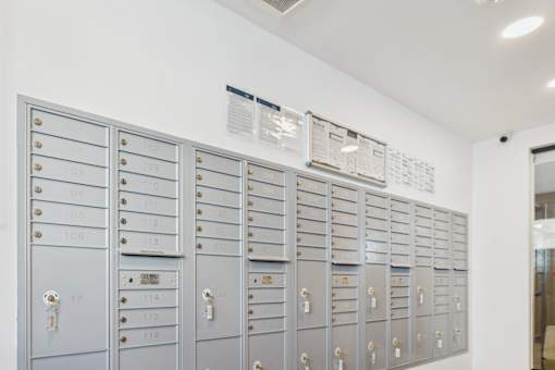 A row of mailboxes are lined up against a wall.