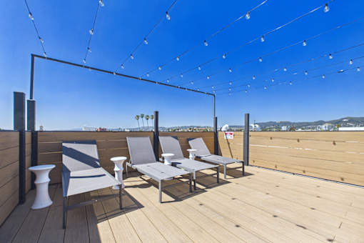 A wooden deck with chairs and a table.