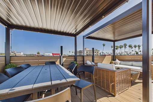 A patio with a table and chairs under a roof.