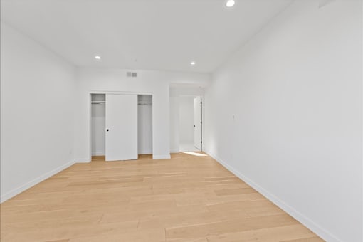 A room with wooden flooring and white walls.