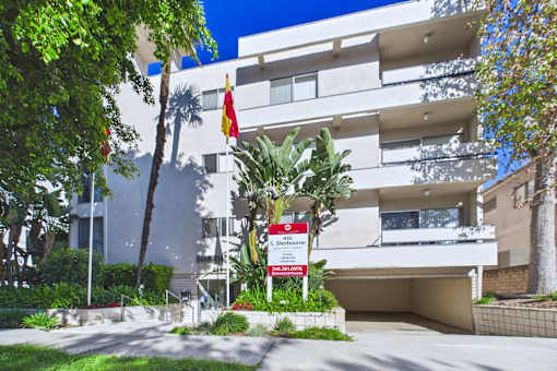 A white building with a red and white sign in front of it.