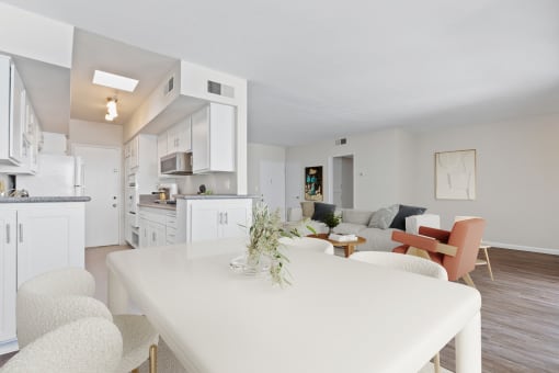 a living room and kitchen with a white table