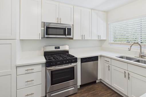 A kitchen with white cabinets and stainless steel appliances.