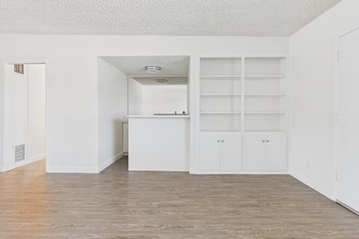 A white room with a cabinet and shelves.