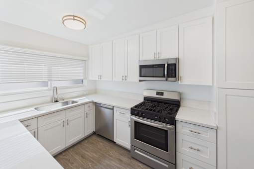A kitchen with white cabinets and a black stove top oven.