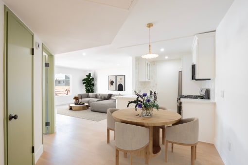 a living room and dining room with a table and chairs