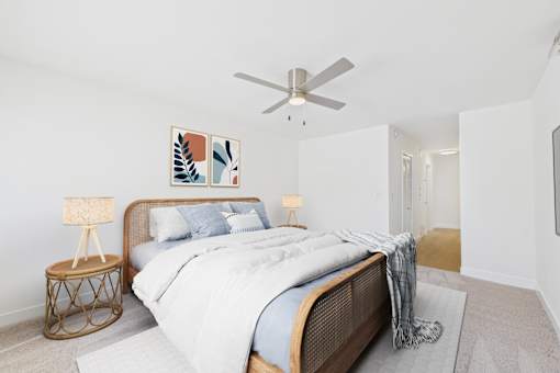 A bedroom with a large bed and a ceiling fan.