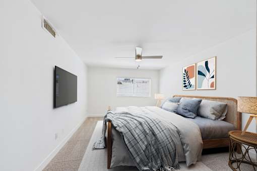 A bedroom with a bed, a chair, and a television.