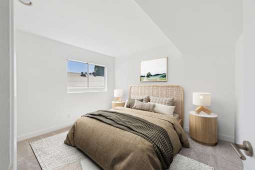 A bedroom with a large bed and a painting on the wall.