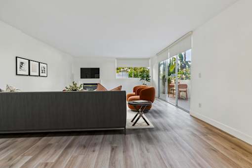 A living room with a brown chair and a black couch.