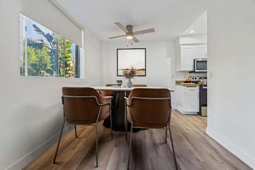 A dining room with a table and chairs.