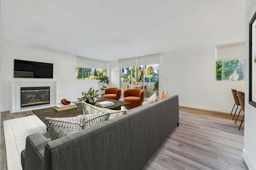 A living room with a grey couch and a fireplace.