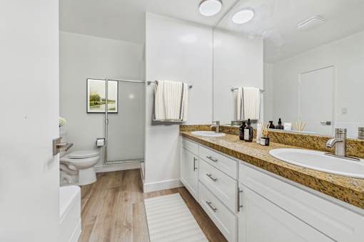 A bathroom with a toilet, sink, and mirror.