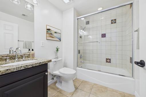 A bathroom with a toilet, sink, and shower.