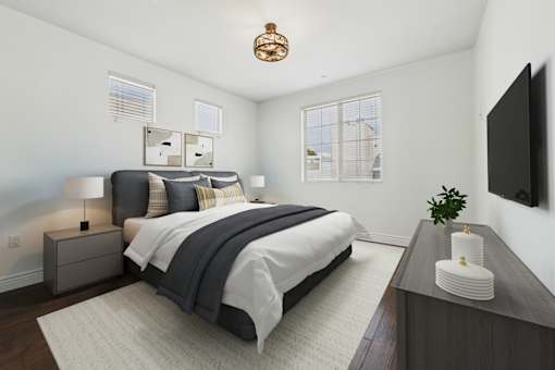 A bedroom with a large bed and a flat screen TV mounted on the wall.