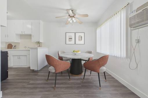 A kitchen with a dining table and chairs.