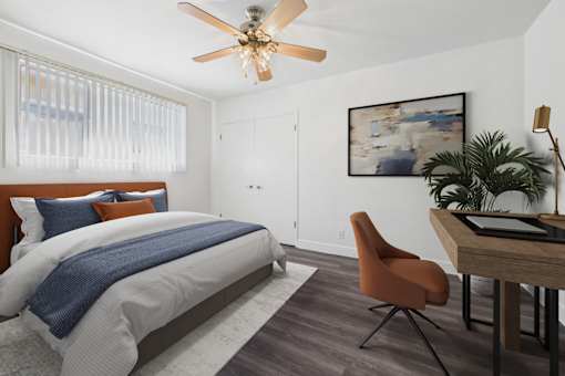 A bedroom with a bed, desk, and chair.