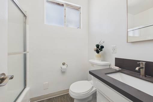 A white toilet sits next to a sink in a bathroom.