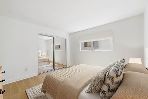 A bedroom with a bed and a mirror on the wall.