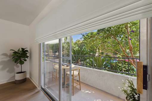 A patio with a table and chairs is visible through a sliding glass door.