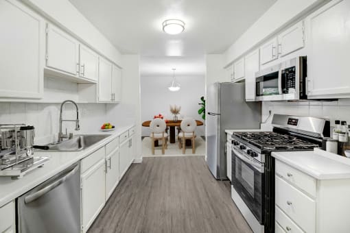 a kitchen with stainless steel appliances and white cabinets