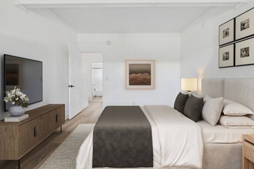A bedroom with a large bed and a flat screen TV.