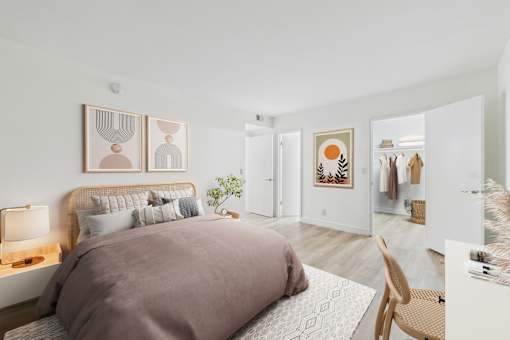 A bedroom with a large bed and a chair.