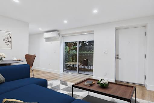 A blue couch sits in a living room with a coffee table in front of it.