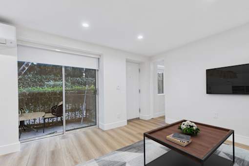 A modern living room with a sliding glass door leading to a patio.