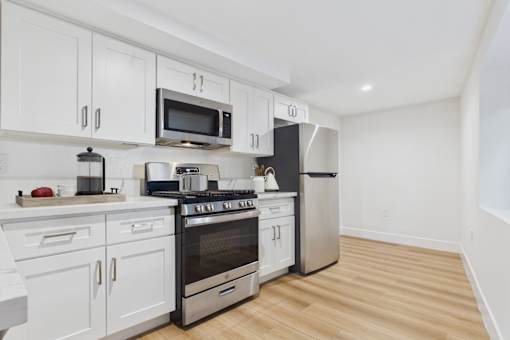 A kitchen with white cabinets and stainless steel appliances.
