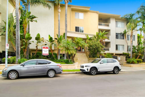 two cars parked in front of an apartment building