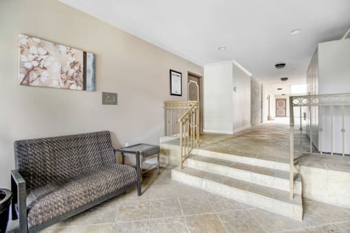 a living room with a couch and a hallway with stairs