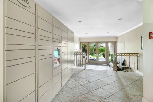 a long hallway with white cabinets and a door to a house