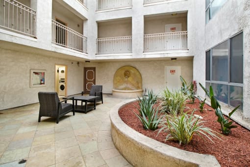 a courtyard with a table and chairs and a fountain