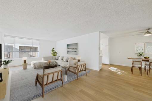 A living room with a couch, chairs, and a rug.