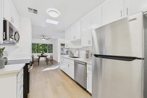 A modern kitchen with white cabinets and stainless steel appliances.