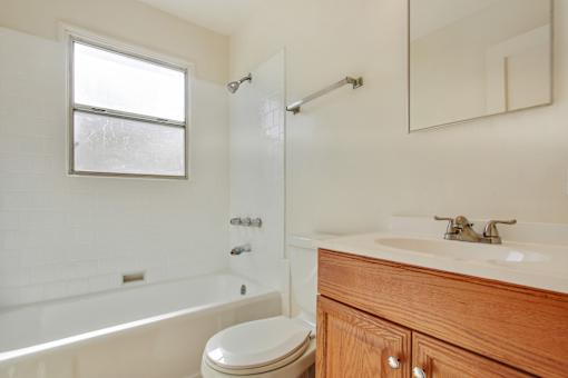 A white bathroom with a toilet, sink, and bathtub.